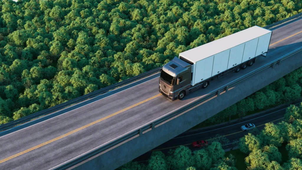 Highway with trucks and cars next to a logistics port and parked vehicles, representing transportation and freight flow.