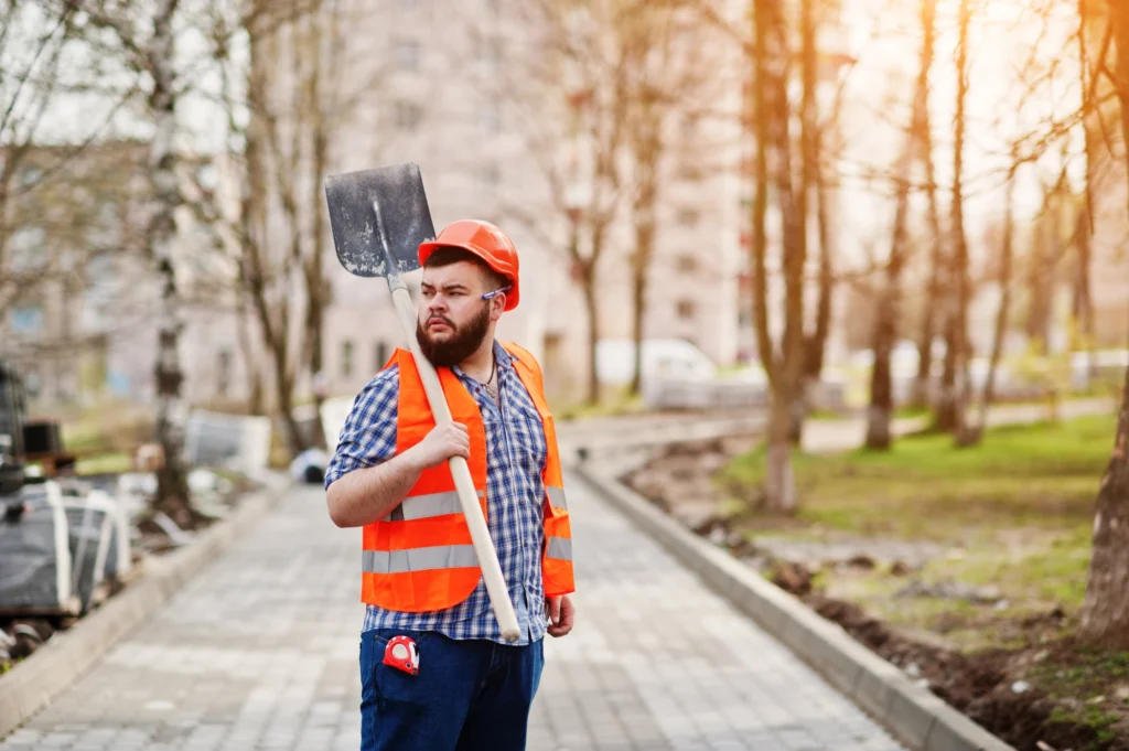 Utility worker marking underground service line with a locator on a job site