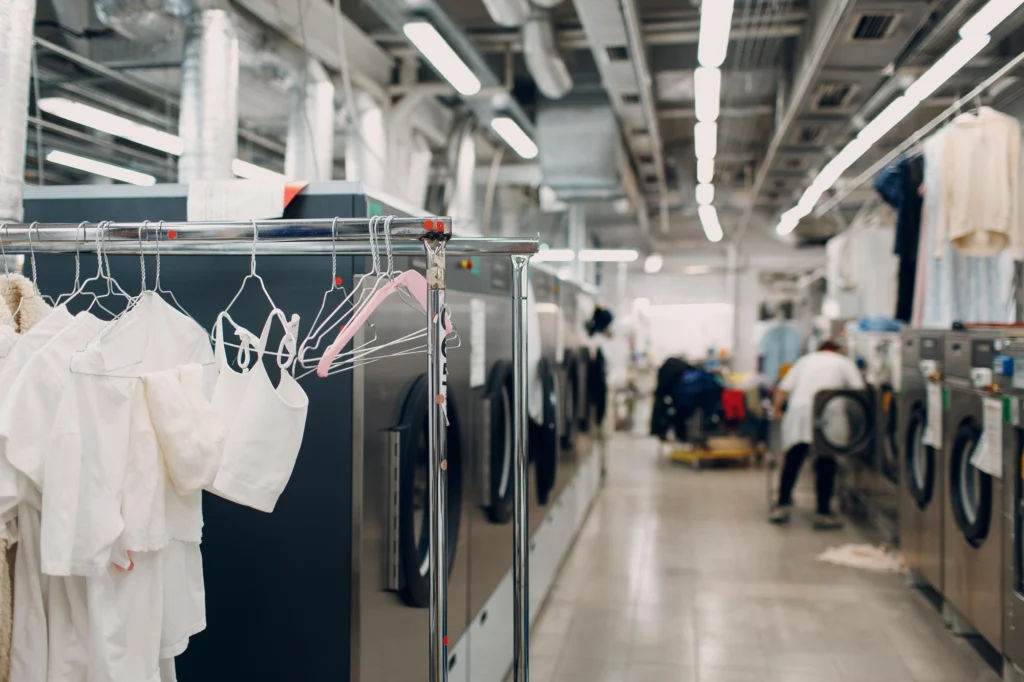 Technician servicing industrial laundry machines in a commercial laundry facility — Shifton Field Service
