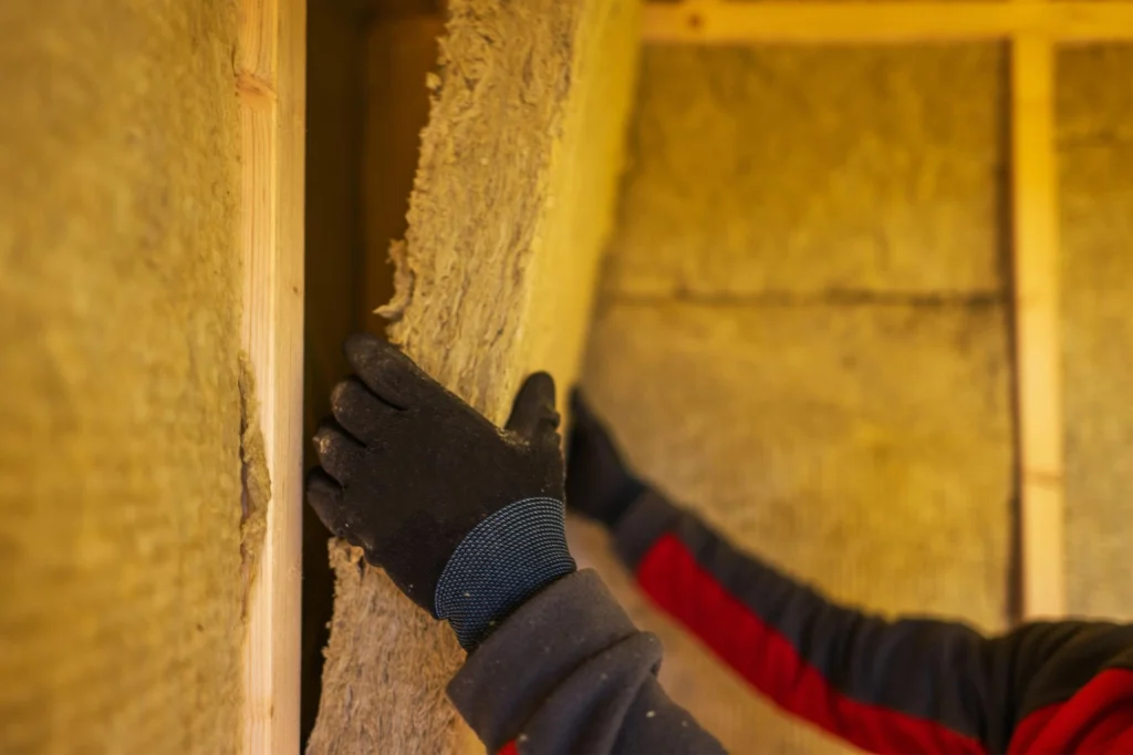 Insulation technicians installing thermal insulation panels on a construction site — field service work