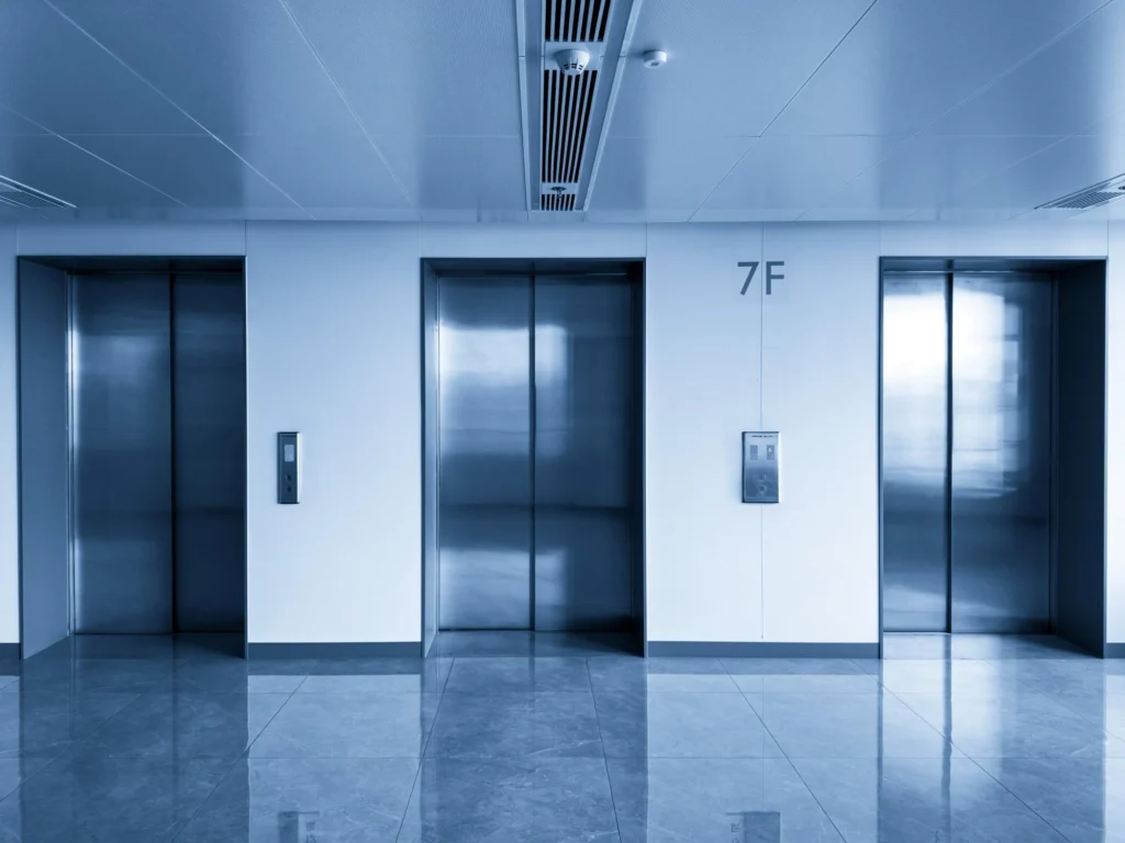Technician performing maintenance inside an elevator shaft with lift cables visible — Shifton Field Service