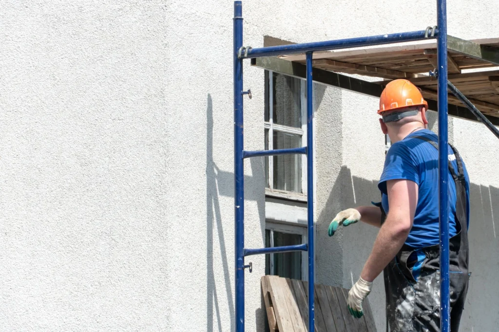Workers repairing and cleaning a building façade on scaffolding — Shifton Field Service