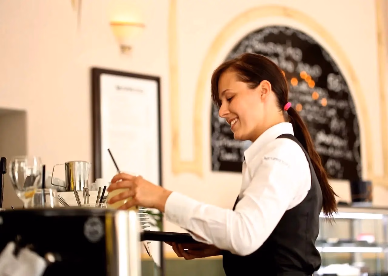 Engaging server enhances café experience with warmth and professionalism in a cozy atmosphere.